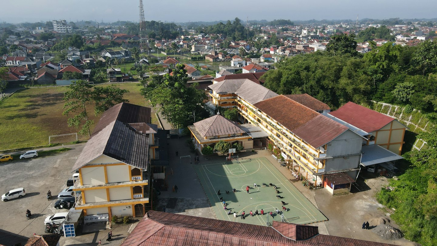 Siswa berlatih di lapangan luar kompleks sekolah.