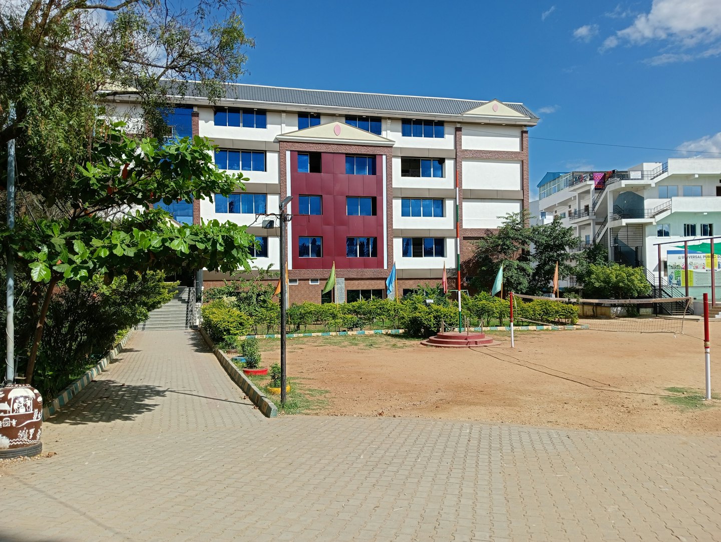Gedung sekolah modern dengan bagian merah dan jendela biru.